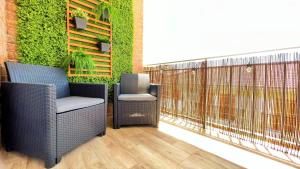 un patio con 2 sillas y una pared verde en La Torre - terraza y vistas al mar, en Torre de la Horadada