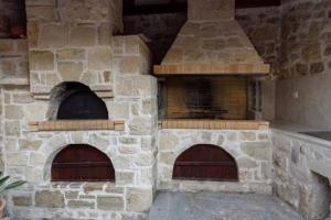 an outdoor pizza oven with two pizzas in it at Pyrgou Villa with Shared Swimming pool in Heraklio Town