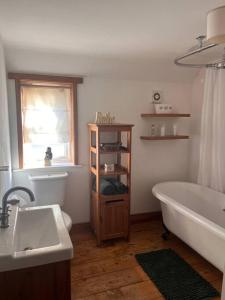 a bathroom with a tub and a sink and a bath tub at The Paddocks in Moulton Chapel