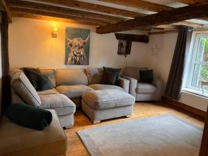 a living room with a couch and a cow picture on the wall at The Paddocks in Moulton Chapel