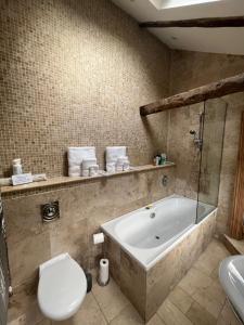 a bathroom with a tub and a toilet and a sink at The Garden Suite in Harrogate