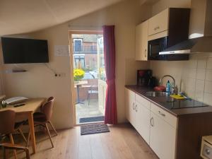 a kitchen with a table and a dining room at Appartement Canberra. in Bergen aan Zee