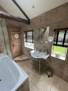 a bathroom with a tub and a sink and a bath tub at The Garden Suite in Harrogate