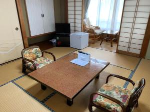 sala de estar con mesa y sillas en HOTEL LT Kitchen 湯河原, en Yugawara