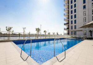 a swimming pool with blue water in a building at Cozy Chic Corner G04WB3 in Abu Dhabi