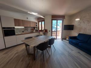 sala de estar con mesa de madera y sofá azul en MGH Family Apartment Aprica - Gran Paradis en Aprica