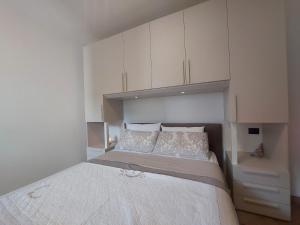1 dormitorio con 1 cama grande y armarios blancos en MGH Family Apartment Aprica - Gran Paradis en Aprica