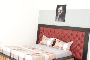 a bed with a red headboard in a room at KRISTAL HOME in Yaoundé