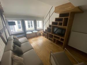 uma sala de estar com um sofá e uma televisão em TRIPLEX NEUVICE em Liège