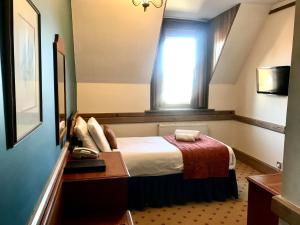 a hotel room with a bed and a window at Purbeck House Hotel & Louisa Lodge in Swanage