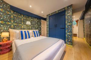 a bedroom with a bed and a blue door at A fairy-tale luxurious cottage - The Tea Caddy in Colchester