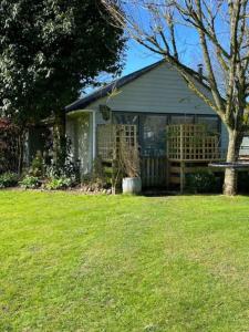 a house with a bench in a yard at ‘The Den’ Self contained one bedroom annexe. in Stockbridge