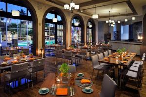 a restaurant with tables and chairs and windows at Amman Marriott Hotel in Amman