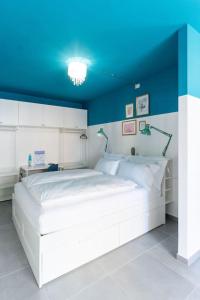 um quarto com uma grande cama branca e um tecto azul em CASA FIUMICELLO - VERONETTA em Verona