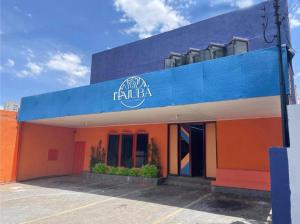 un bâtiment orange et bleu avec un panneau sur lequel figure un panneau dans l'établissement Itajubá Classic Hotel Goiânia, à Goiânia