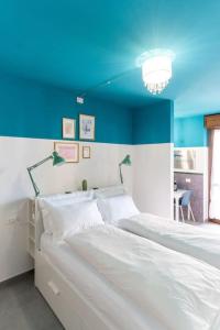 um quarto com uma cama branca e um tecto azul em CASA FIUMICELLO - VERONETTA em Verona
