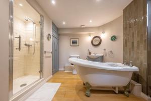 a bathroom with a tub and a shower and a toilet at A fairy-tale luxurious cottage - The Tea Caddy in Colchester