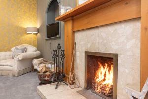 a living room with a fireplace with a fire at Maxwelston Farmhouse in Girvan