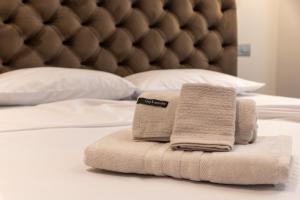 una pila de toallas sentadas encima de una cama en Nicolas Centrale-Smart City Suites en Igoumenitsa