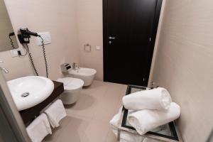 ein weißes Bad mit einem Waschbecken und einem WC in der Unterkunft Palazzo Indelli in Monopoli