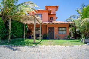 a house with palm trees in front of it at Meu Paraíso em Búzios - 70 metros da Praia in Búzios