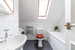 a white bathroom with a toilet and a sink at The Lewisham Flats in London
