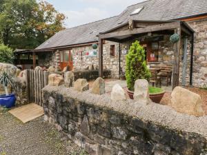 a stone house with a stone fence and a stone wall at Barn 1 in Swansea