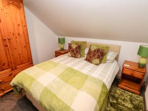a bedroom with a bed and two lamps on night stands at Barn 1 in Swansea