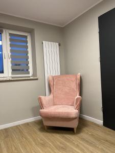 a pink chair in a room with a window at WOW HOME in Warsaw