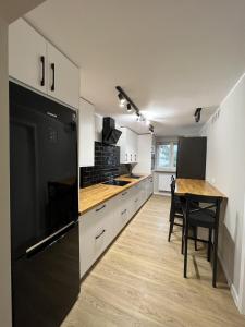 a kitchen with a table and a black refrigerator at WOW HOME in Warsaw