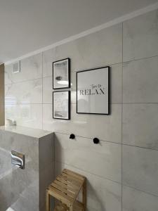 a bathroom with three framed pictures on the wall at WOW HOME in Warsaw