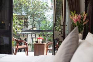 a balcony with a table and chairs and flowers at La Madera Hotel & Spa in Hanoi