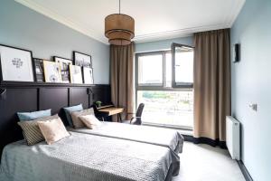 a bedroom with a large bed and a window at Apartments Jaglana with Parking & SPA in Gdańsk