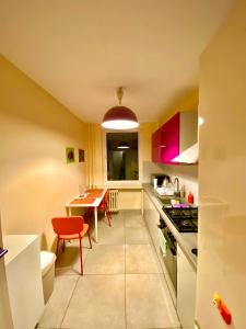 een keuken met een tafel en een rode stoel bij Cheap entire apartment in a super location in Krakau