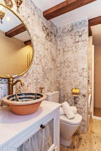 uma casa de banho com um lavatório, um WC e um espelho. em tuGuest Nazarí Calderería Apartments em Granada
