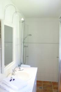 een witte badkamer met een wastafel en een douche bij Kätchen am Schlossgraben - Schloss Gelting in Gelting