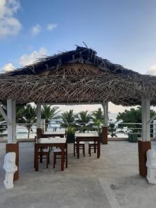 a group of tables and chairs under a straw umbrella at White Surfing Beach Resort in Unawatuna