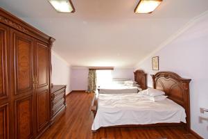 two beds in a bedroom with wooden furniture at TownHouse with pool in Yerevan