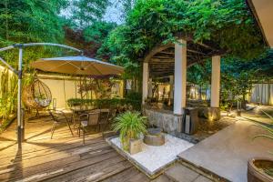 un patio con mesa y sombrilla en Tongli Lanshe Garden B&B en Suzhou