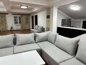 a living room with a white couch and a kitchen at TownHouse with pool in Yerevan