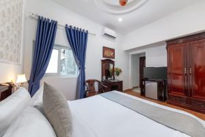 a bedroom with a large bed and a television at La Lisa Hotel in Hanoi