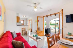 uma sala de estar com um sofá vermelho e uma mesa em Villa Papaya by Villa Plus em Cala en Blanes