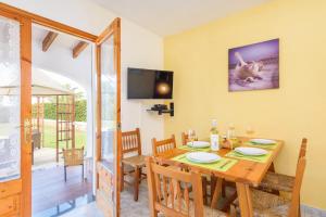 uma sala de jantar e sala de estar com uma mesa de madeira e cadeiras em Villa Papaya by Villa Plus em Cala en Blanes