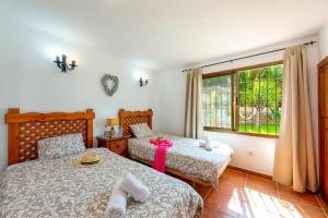 1 dormitorio con 2 camas y ventana en Villa Paraiso Dos by Villa Plus, en Frigiliana