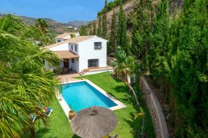 una vista aérea de una casa con piscina y sombrilla en Villa Paraiso Dos by Villa Plus, en Frigiliana