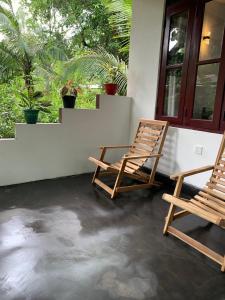 two chairs sitting on the porch of a house at Manju Homestay in Sigiriya