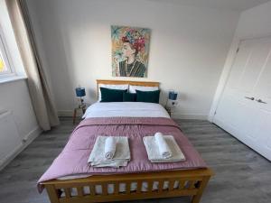 ウォーキングにあるBeautiful Flat In Woking Centralの大きなベッドとタオル2枚のある寝室