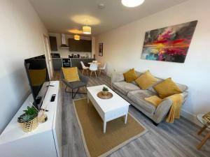 uma sala de estar com um sofá e uma mesa em Beautiful Flat In Woking Central em Woking