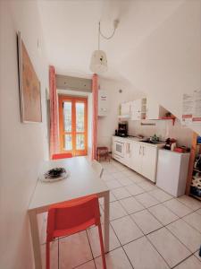 a kitchen with a table and a red chair at B&B Agorà in Biccari