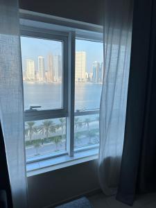 a window with a view of the ocean and a city at sharja p702 in Sharjah